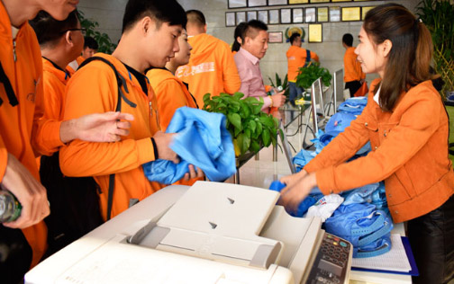 阿里学员在靖邦前台领取车间衣服